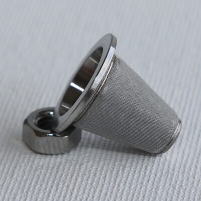 A metal mesh cone filter with a threaded nut, placed on a white textured surface.